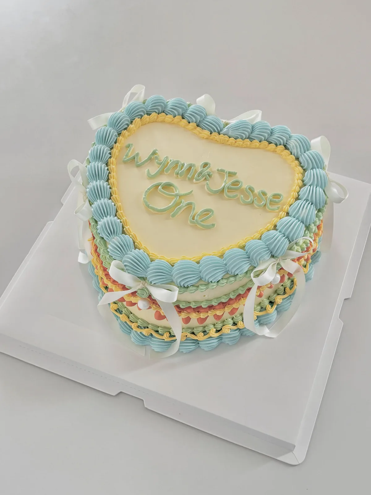 Blue heart cake with multicoloured piped borders, custom cake made in Streatham SW16 - Danine Cakes