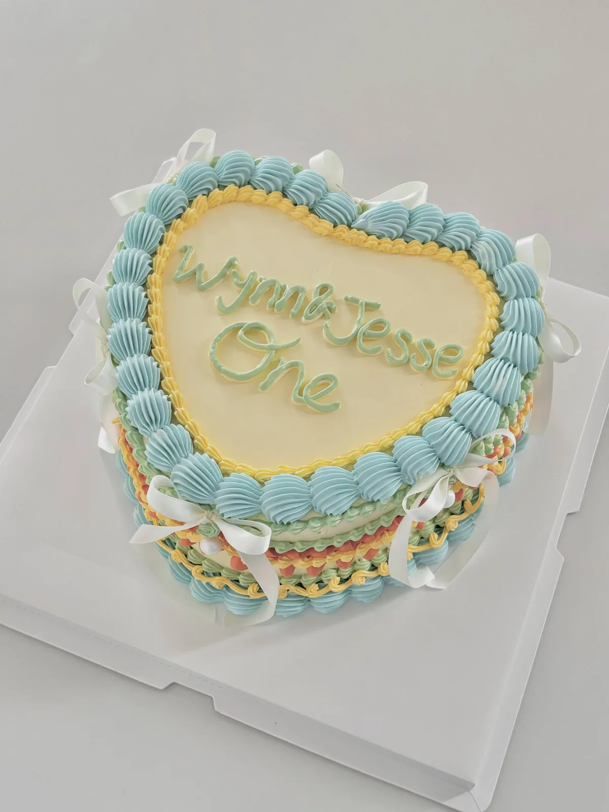 Blue heart cake with multicoloured piped borders, Korean-inspired custom cake handmade in Streatham, London