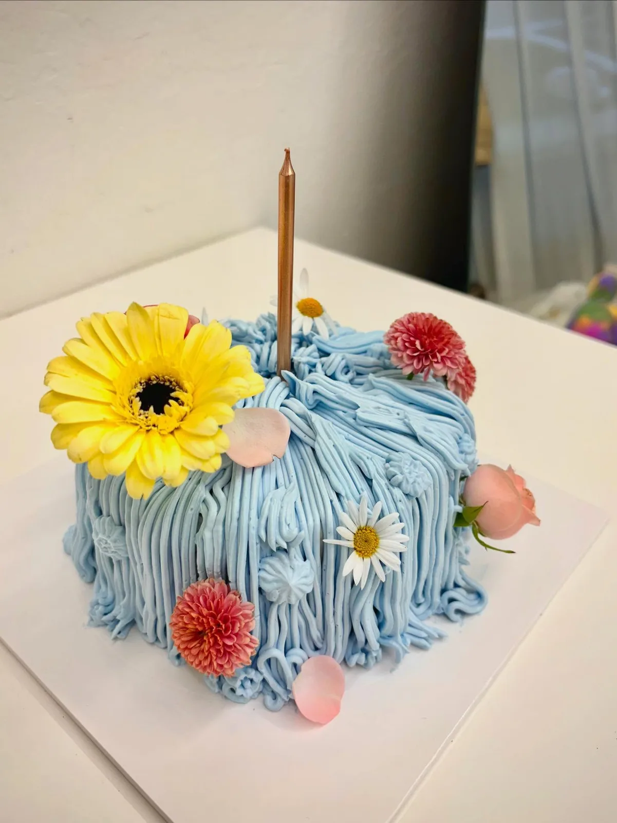 Blue piped strand cake with gerbera daisies and candle, custom cake made in Streatham SW16 - Danine Cakes