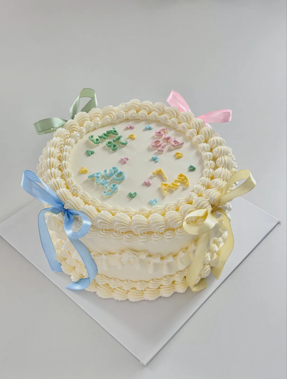 Cream cake with pastel confetti and blue ribbons, custom cake made in Streatham SW16 - Danine Cakes