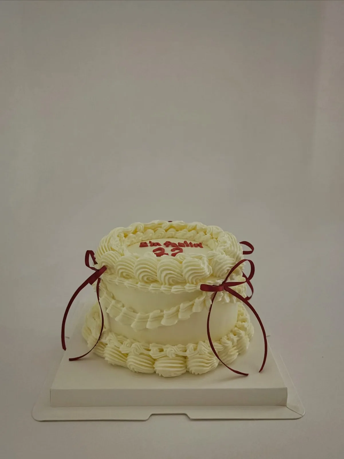 Cream piped cake with red ribbons and lettering, custom cake made in Streatham SW16 - Danine Cakes