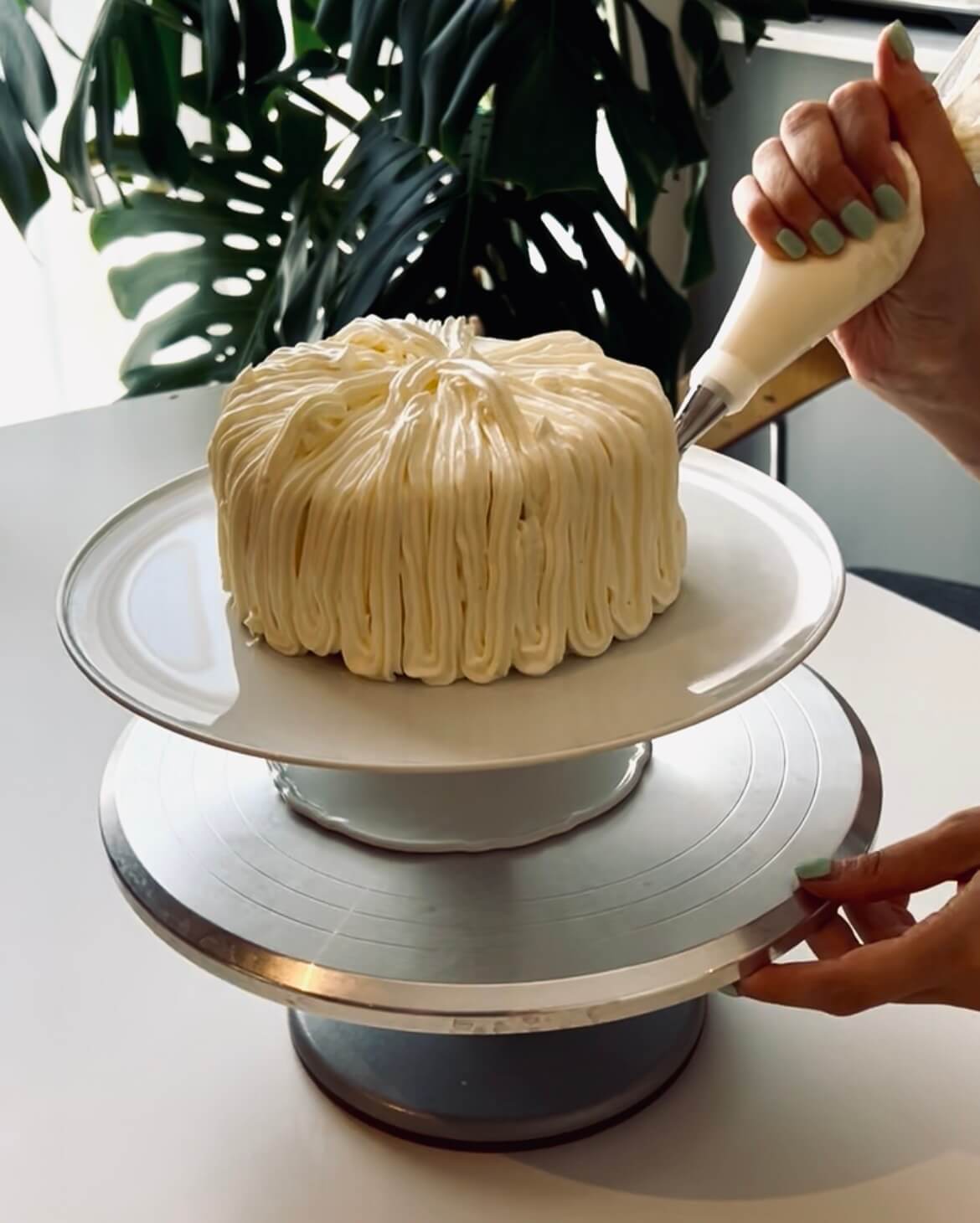 Shinhye, founder of Danine Cakes, hand-piping a Korean-style cake in the Streatham studio