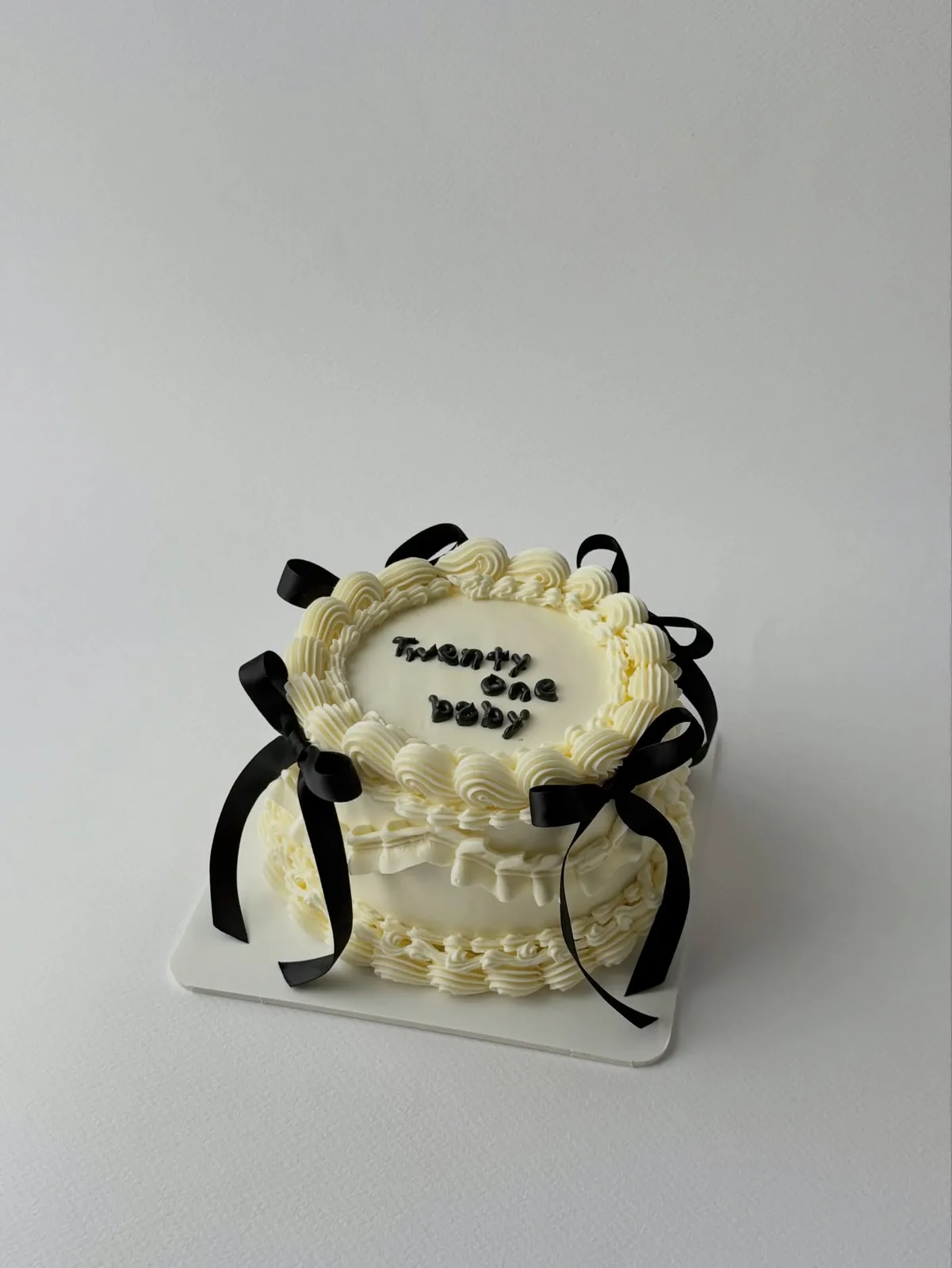 Ivory cake with black bows and piped lettering, custom cake made in Streatham SW16 - Danine Cakes