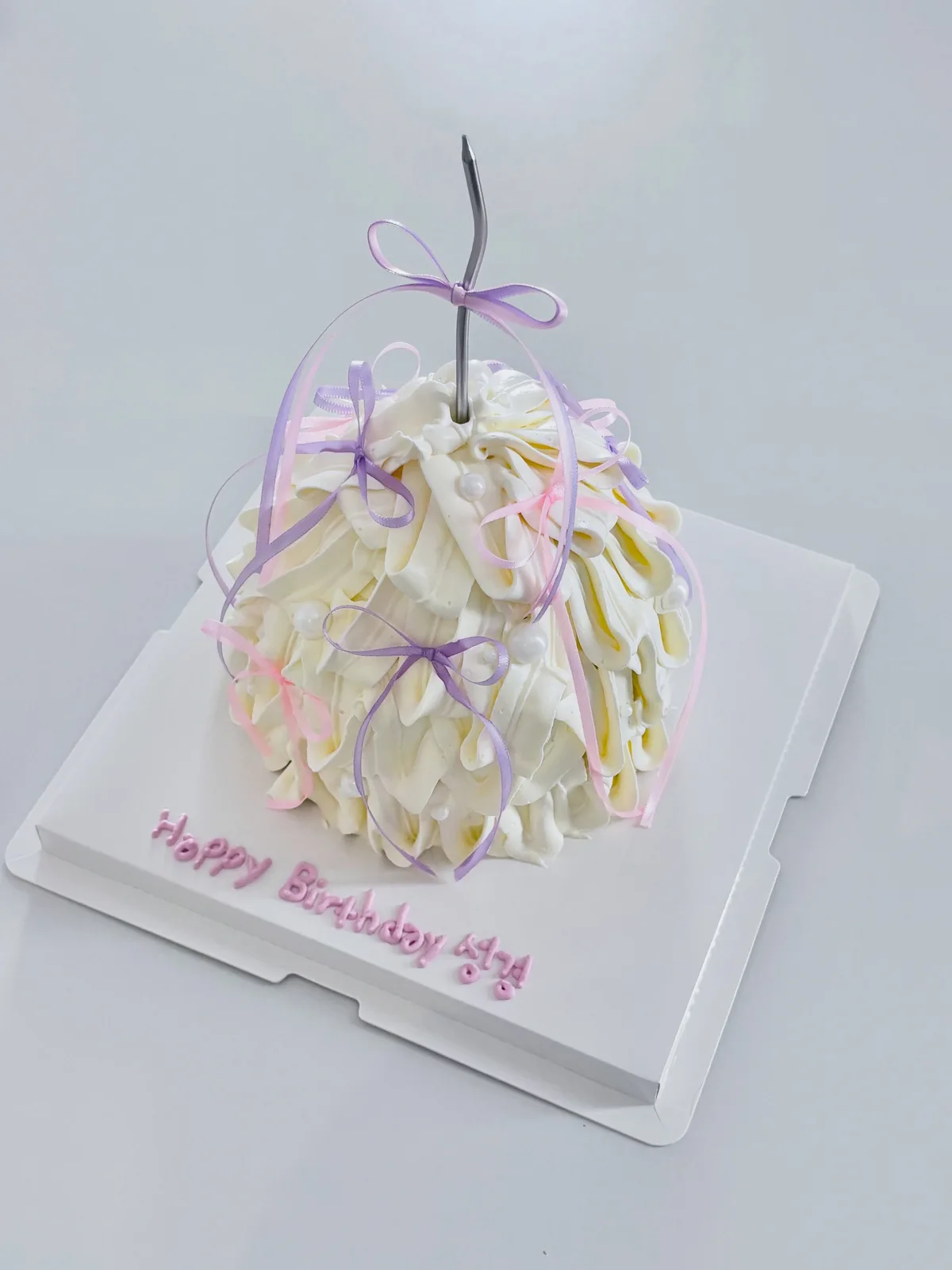 Ivory piped strand cake with lilac ribbons, handmade to order by Danine Cakes in Streatham, South London