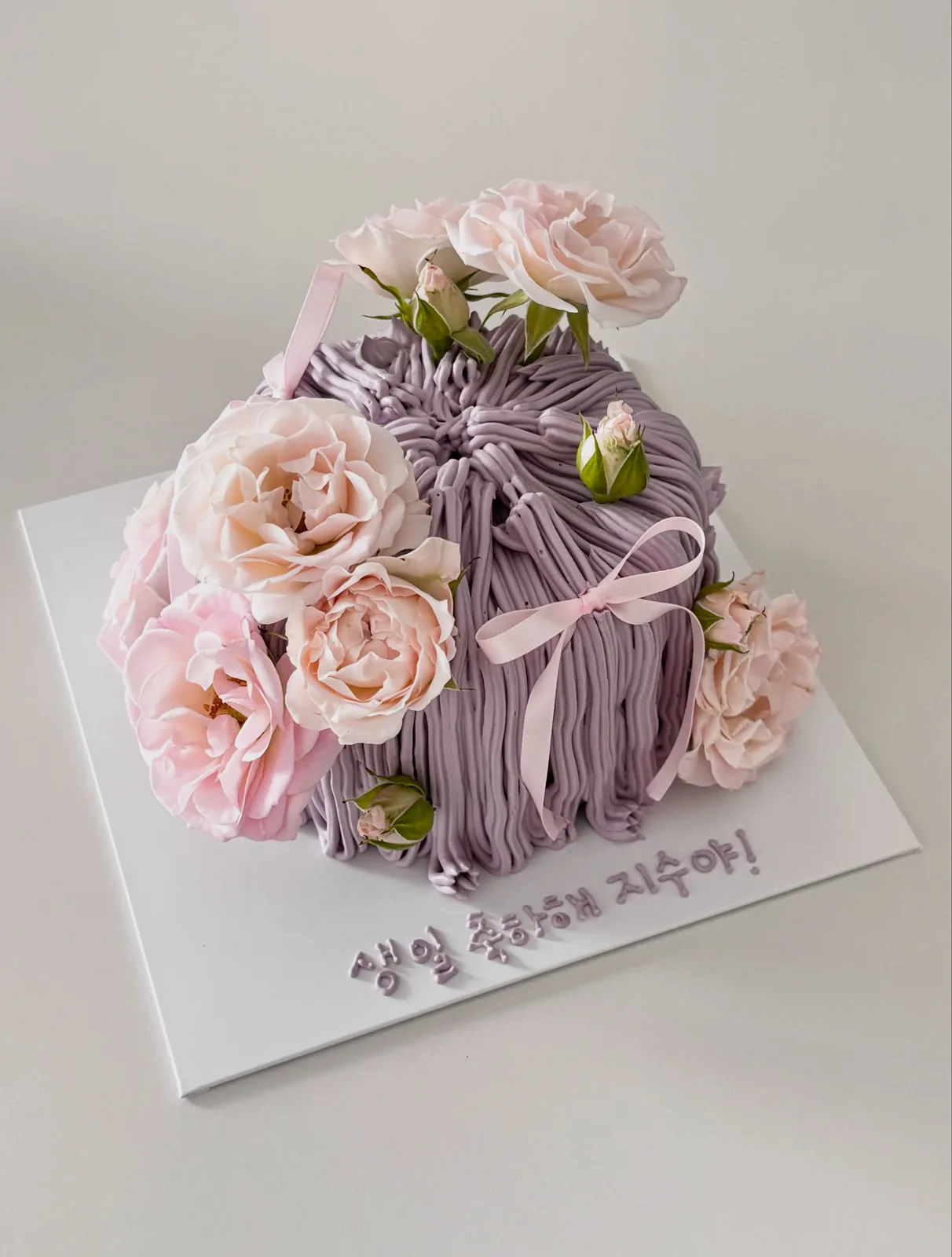 Lilac piped strand cake with fresh roses and pink ribbon, handmade to order by Danine Cakes in Streatham, South London