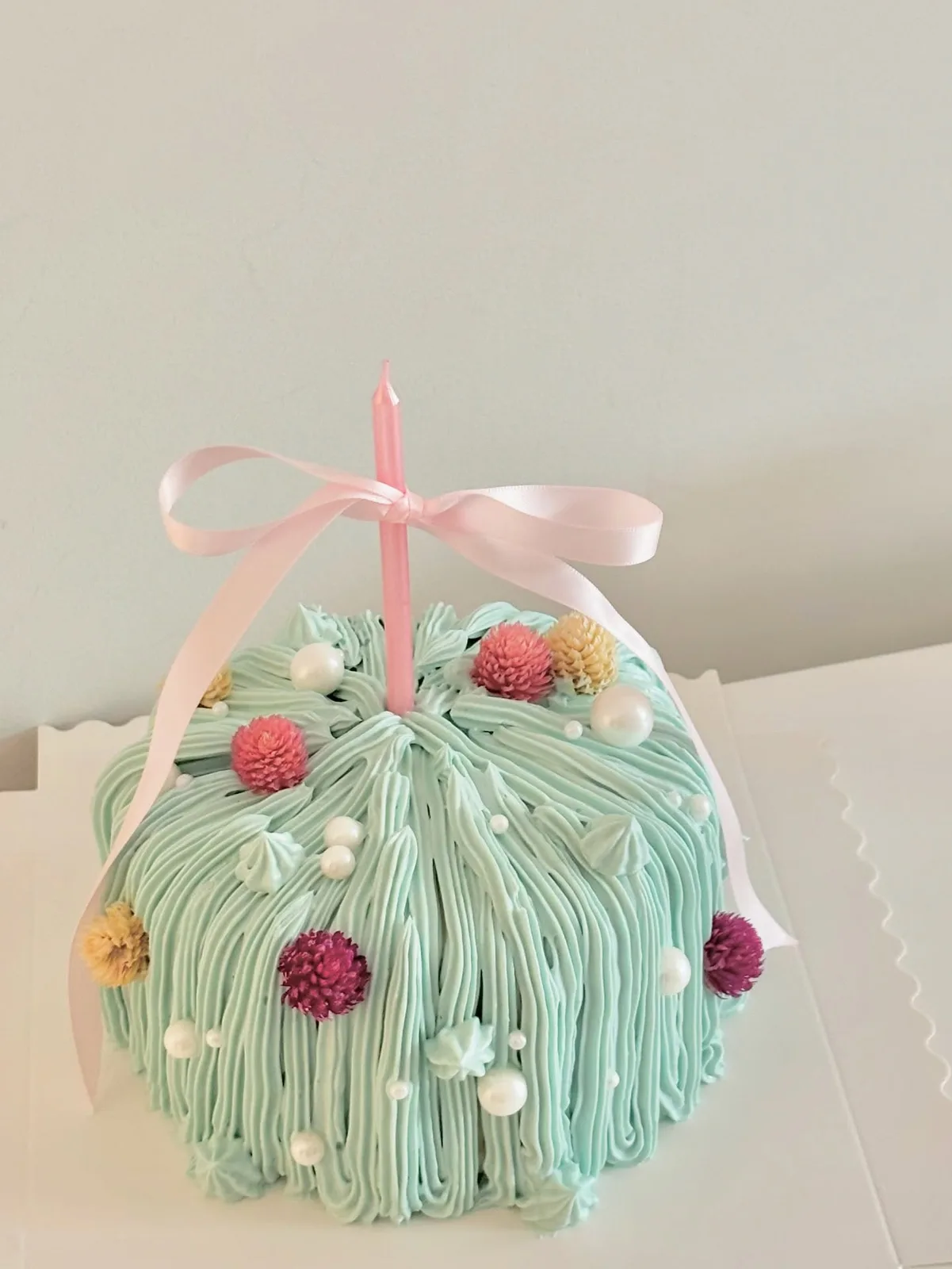 Mint piped strand cake with dried flowers and pink bow, custom cake made in Streatham SW16 - Danine Cakes