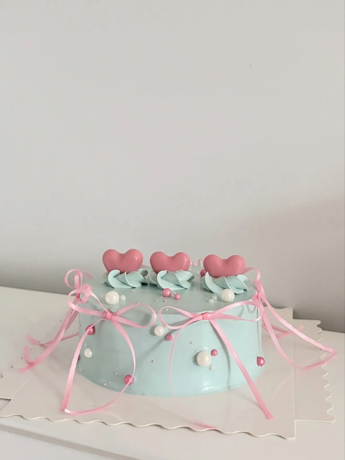 Pale blue cake with pink hearts and ribbon bow, custom cake made in Streatham SW16 - Danine Cakes