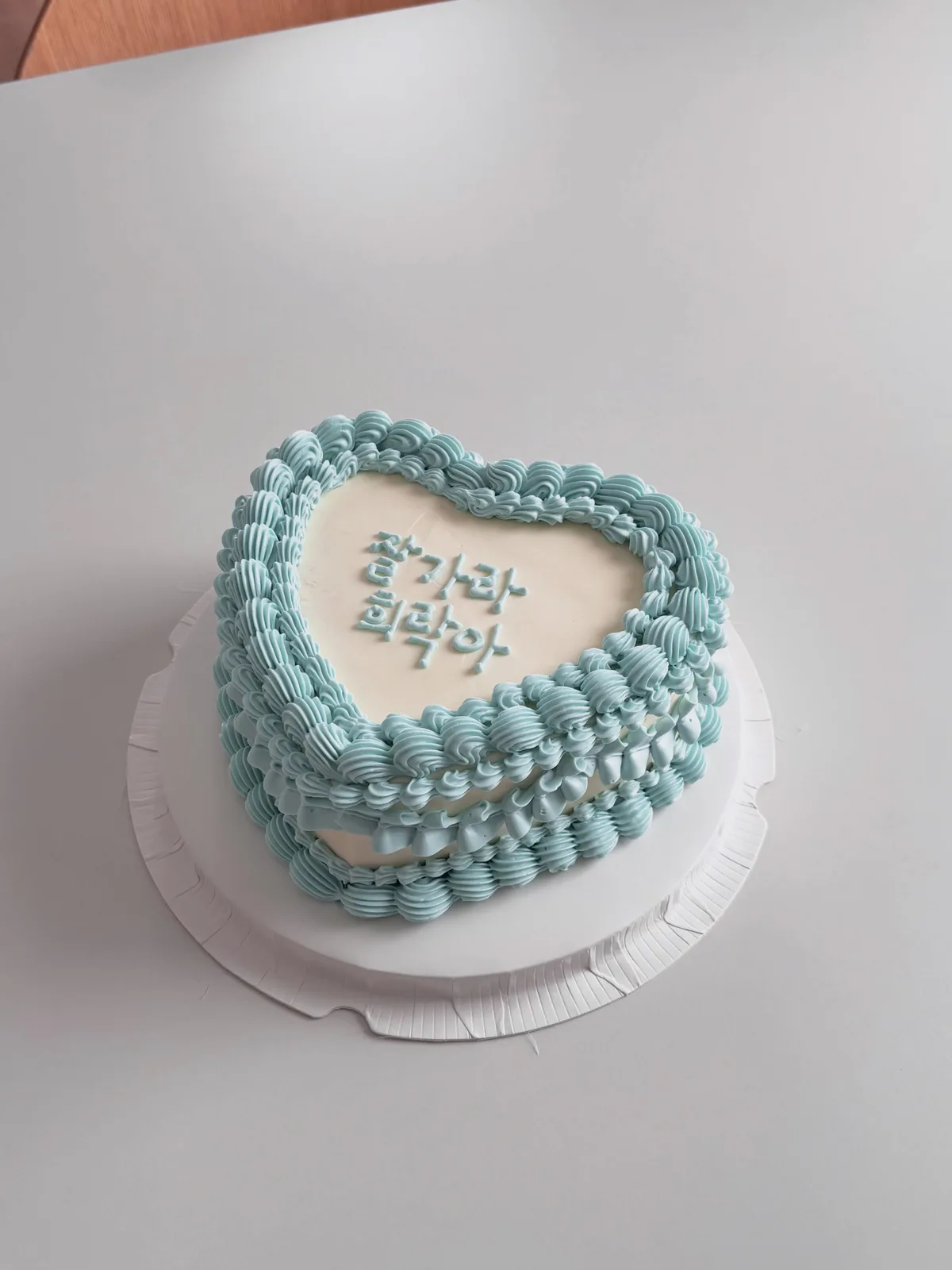 Pale blue heart cake with pearls and Korean lettering, bespoke celebration cake from Danine Cakes, South London