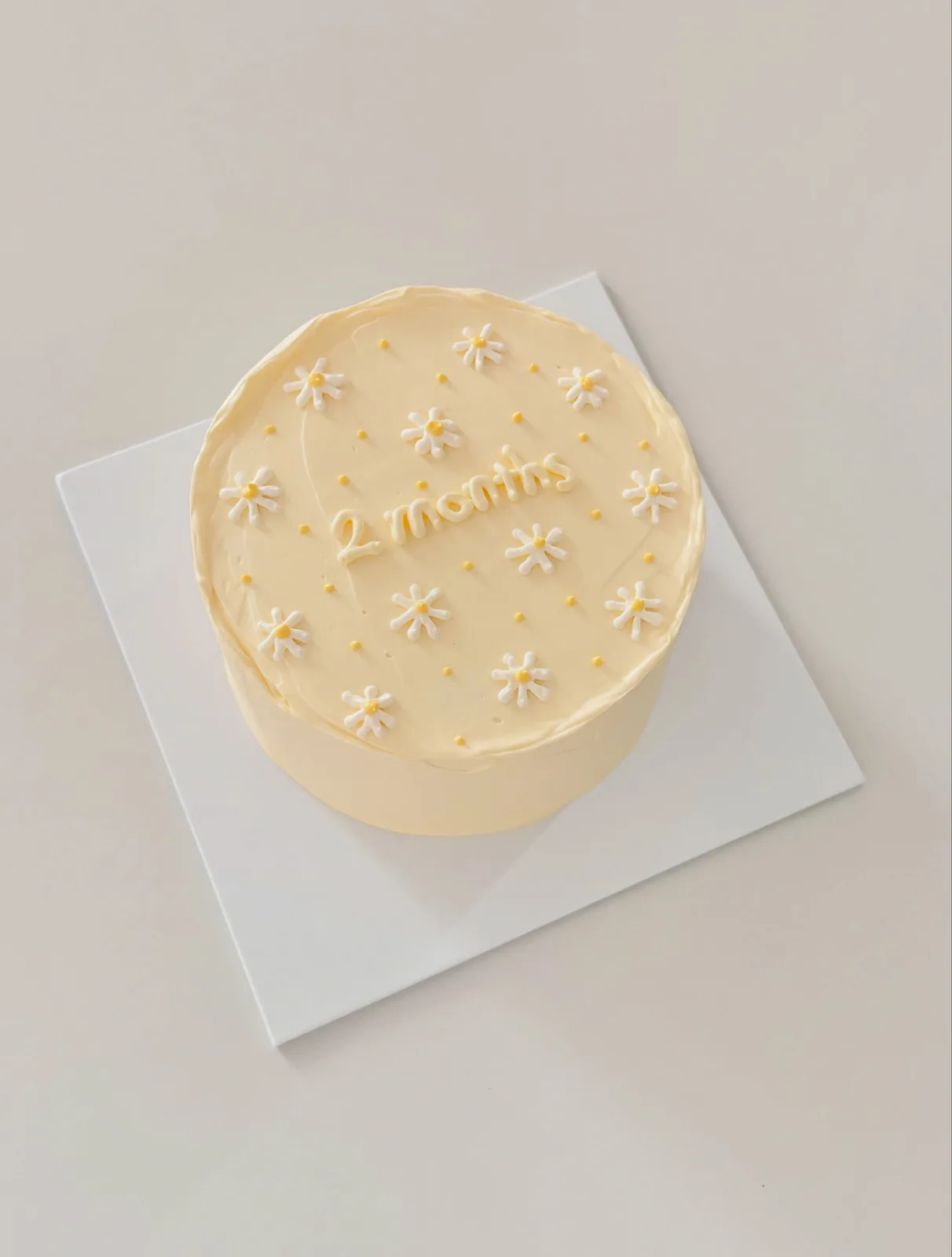 Pale yellow cake with white piped daisies, custom cake made in Streatham SW16 - Danine Cakes