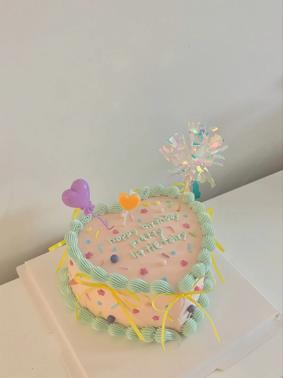 Pastel heart cake with balloon picks and piped border, Korean-inspired custom cake handmade in Streatham, London