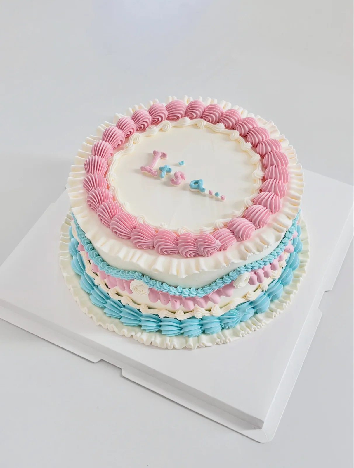 Pink and blue layered cake with piped borders, handmade to order by Danine Cakes in Streatham, South London