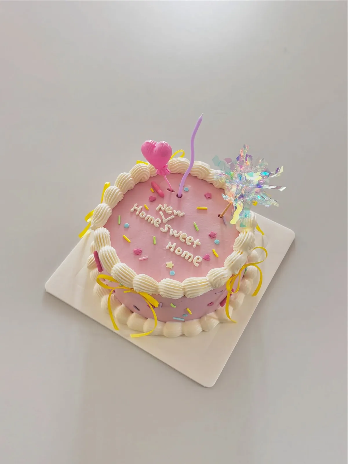 Pink cake with pastel sprinkles and star topper, handmade to order by Danine Cakes in Streatham, South London