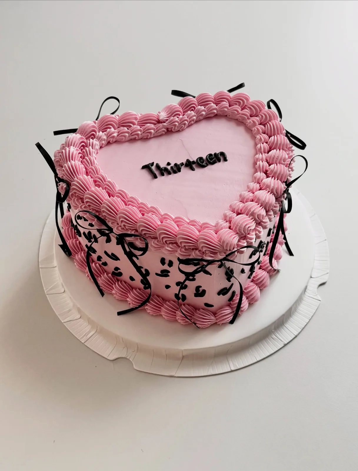 Pink heart cake with black bows and leopard piping, custom cake made in Streatham SW16 - Danine Cakes