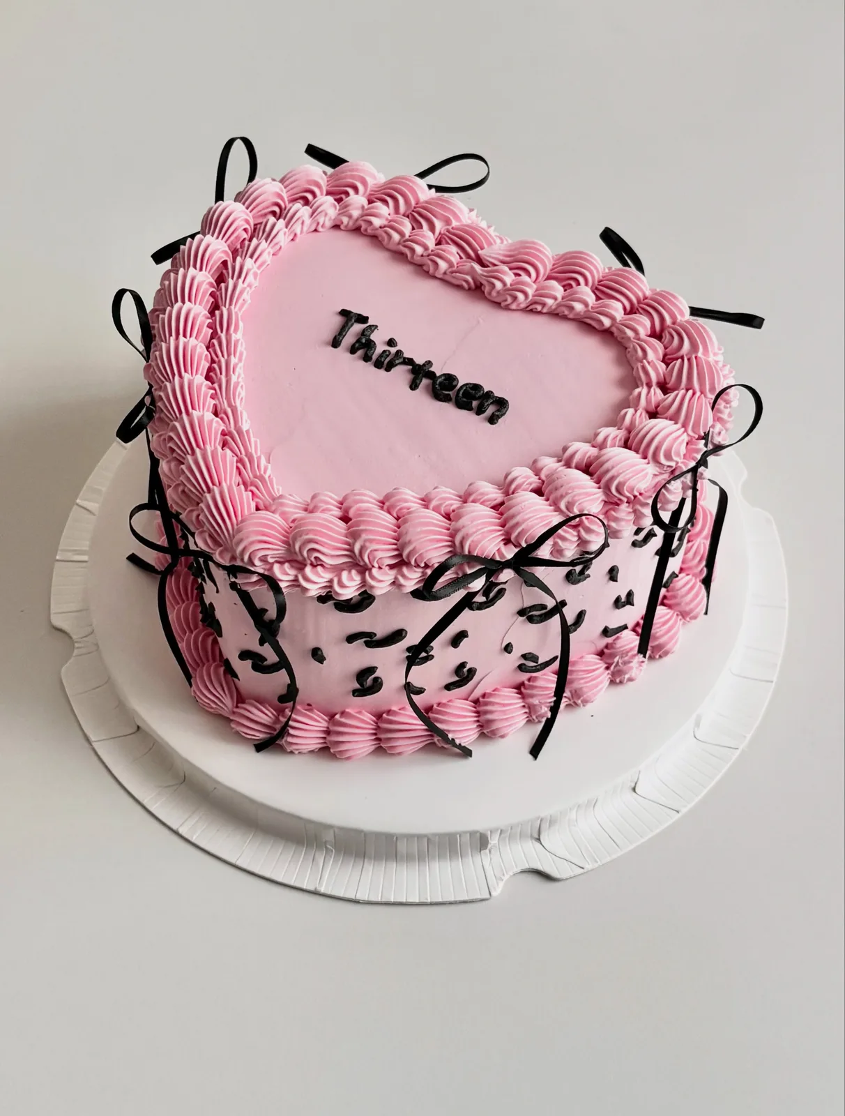 Pink heart cake with black bows and leopard piping, Korean-inspired custom cake handmade in Streatham, London
