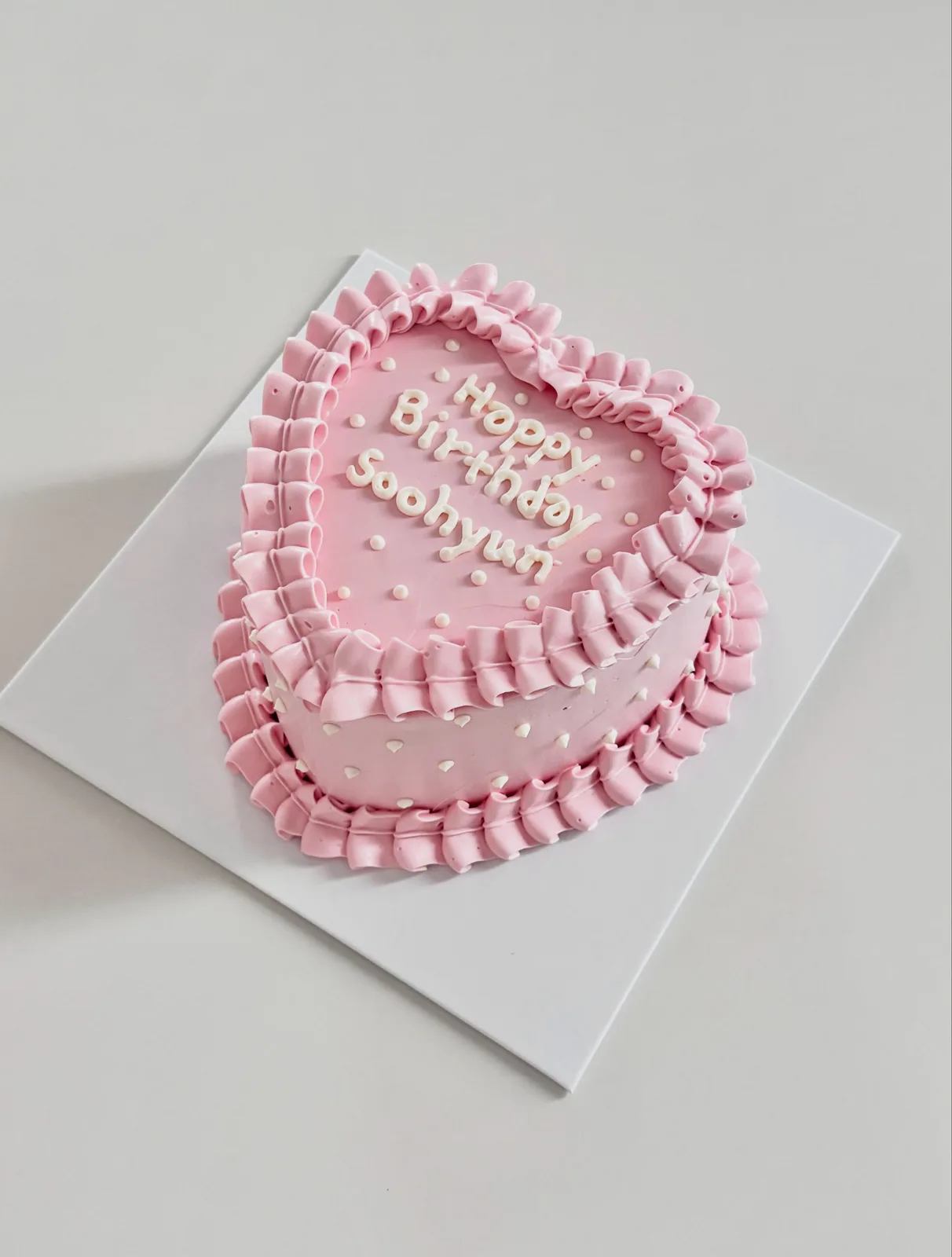 Pink heart cake with pearls and ruffle border, handmade to order by Danine Cakes in Streatham, South London