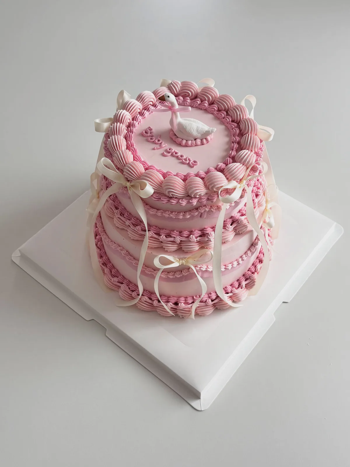 Pink layered cake with piped shells and ribbons, custom cake made in Streatham SW16 - Danine Cakes
