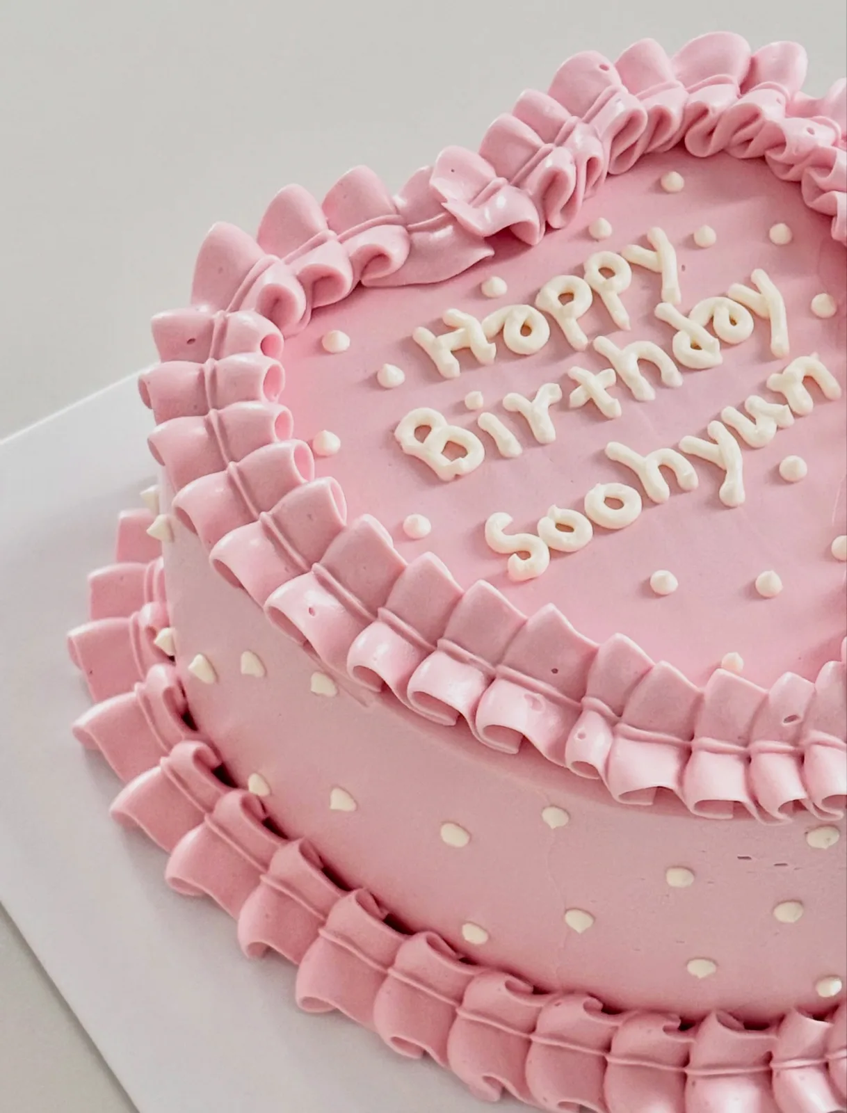 Pink ruffle cake with piped lettering and pearls, handmade to order by Danine Cakes in Streatham, South London