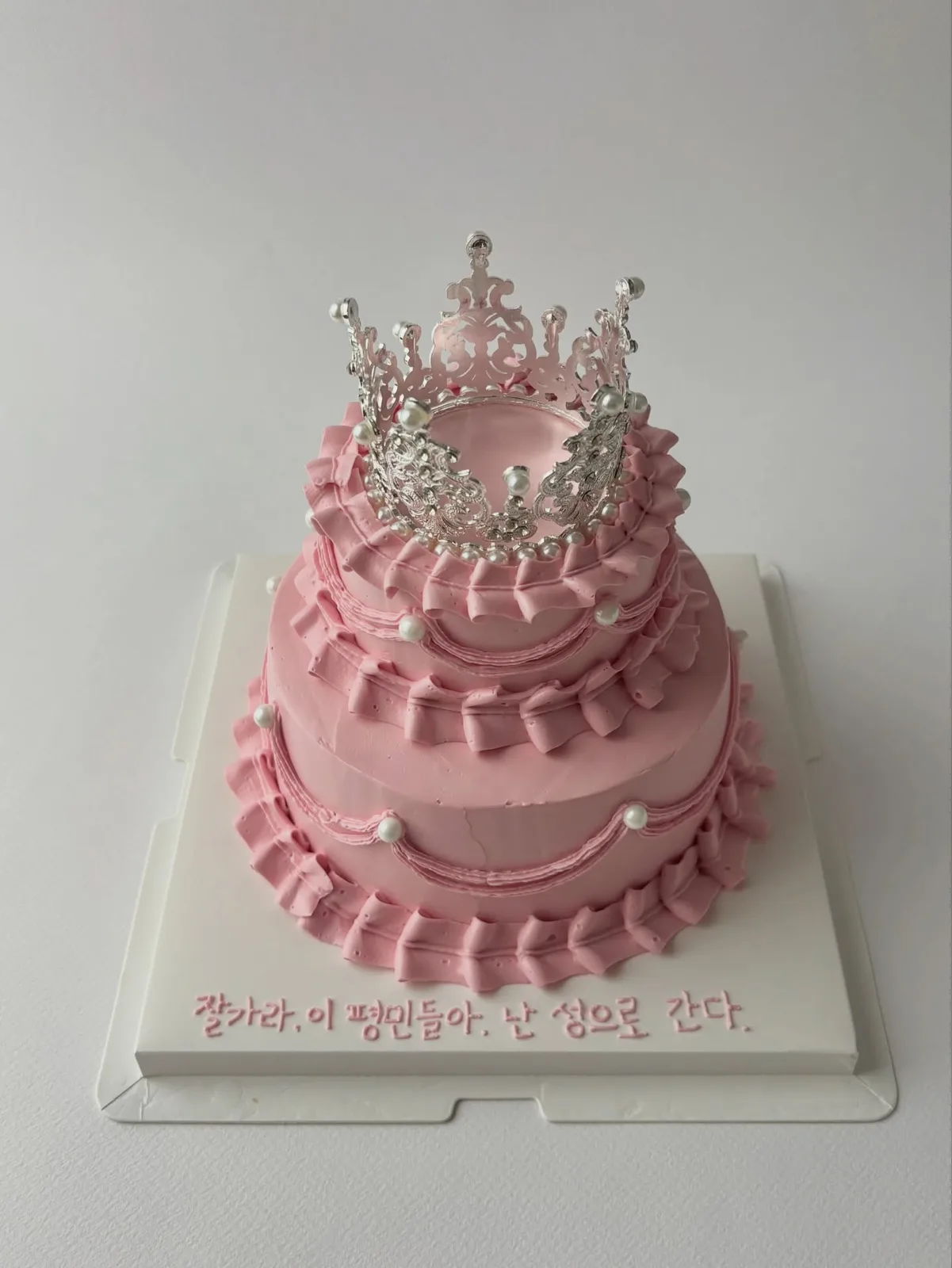 Pink tiered cake with crown topper and piped border, bespoke celebration cake from Danine Cakes, South London
