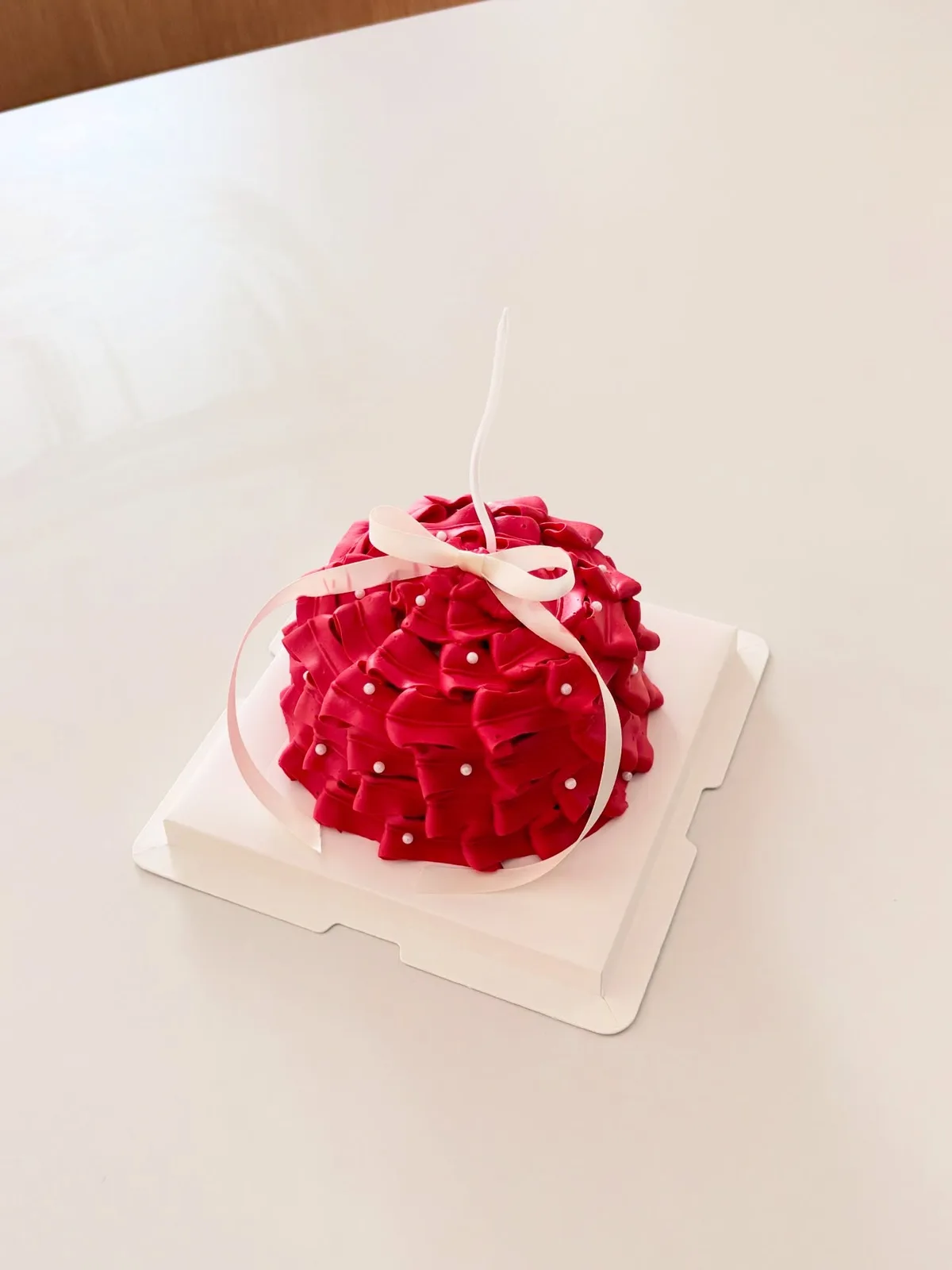 Red piped rosette dome cake with ribbon, bespoke celebration cake from Danine Cakes, South London