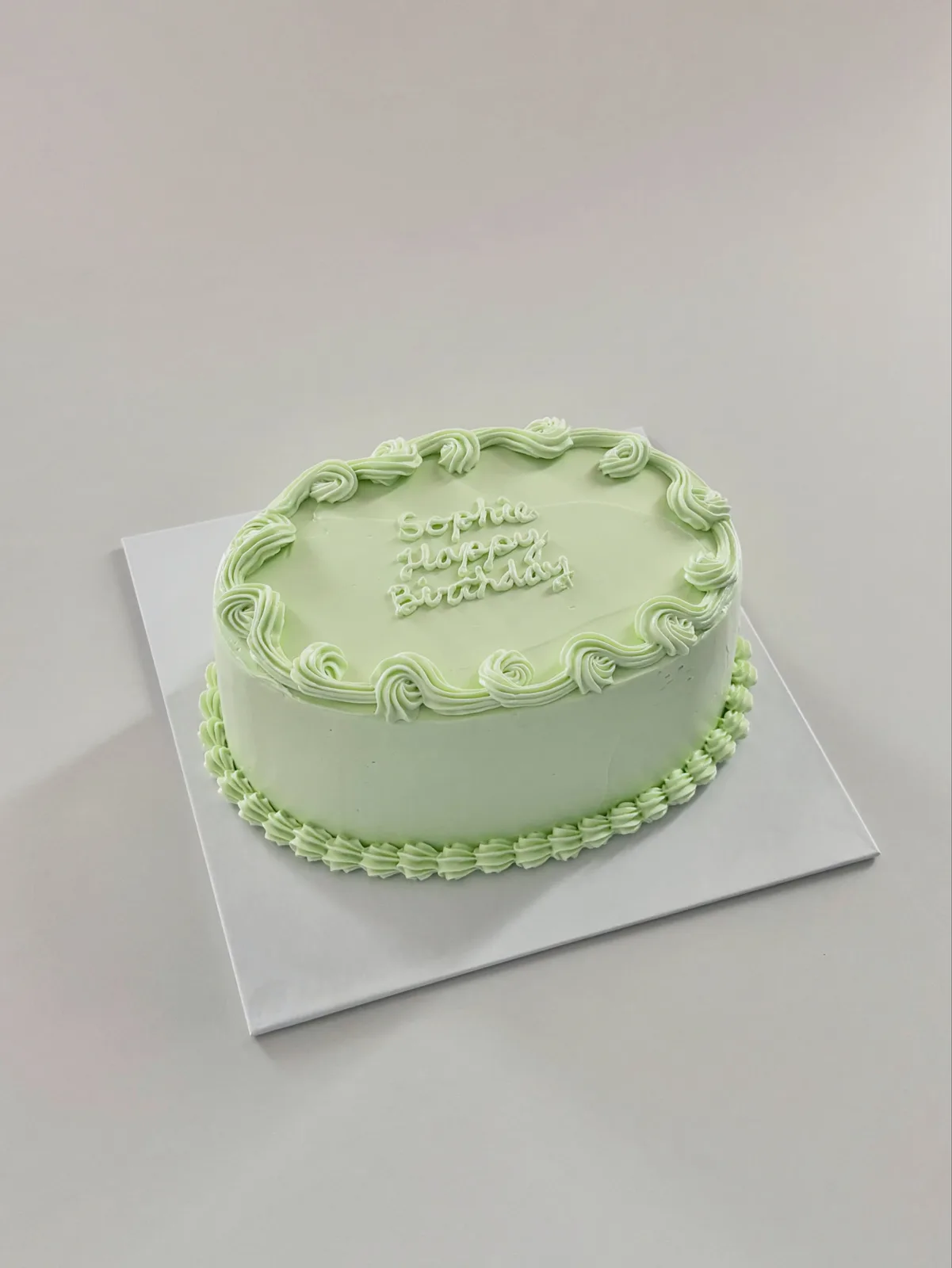 Sage green cake with piped scroll border and lettering, bespoke celebration cake from Danine Cakes, South London
