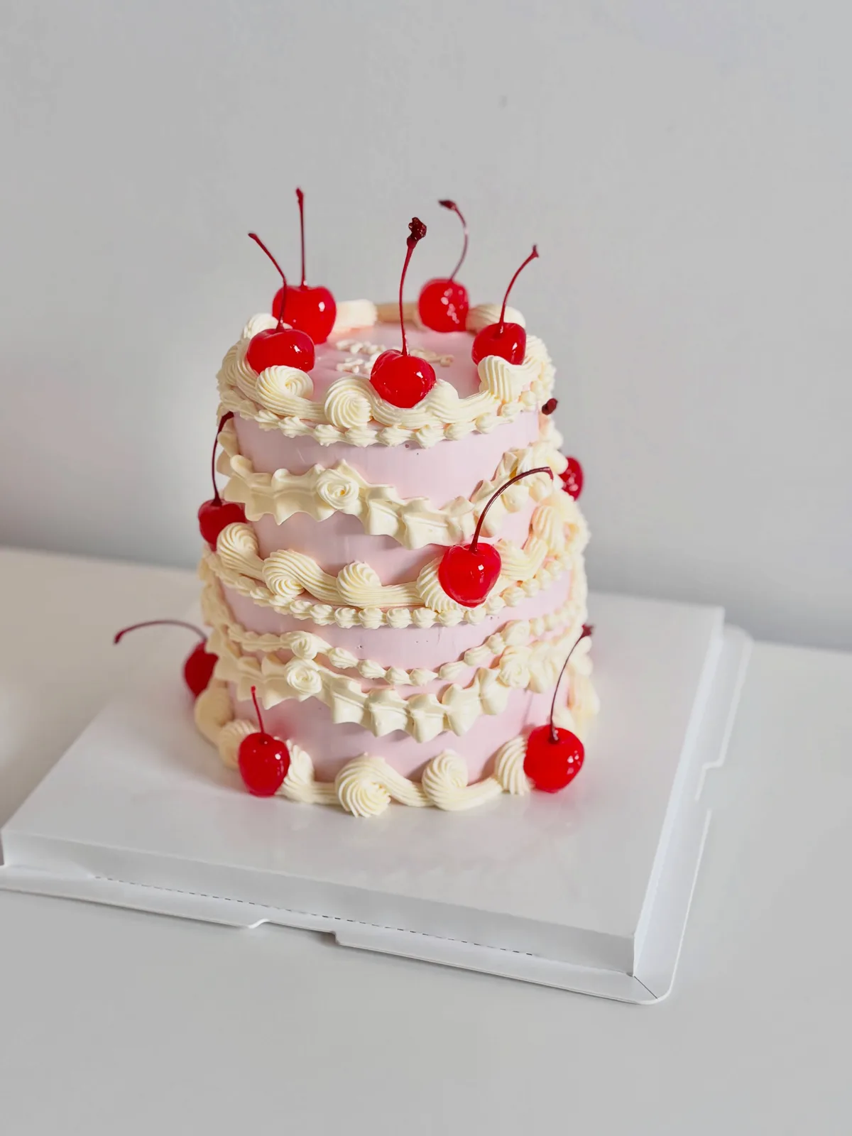 Two tier pink and white cake with cherries and pearls, Korean-inspired custom cake handmade in Streatham, London