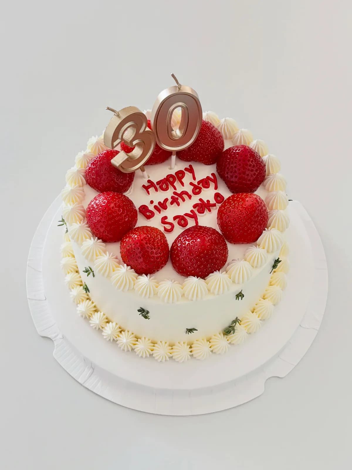 White cake with fresh strawberries and gold candles, bespoke celebration cake from Danine Cakes, South London