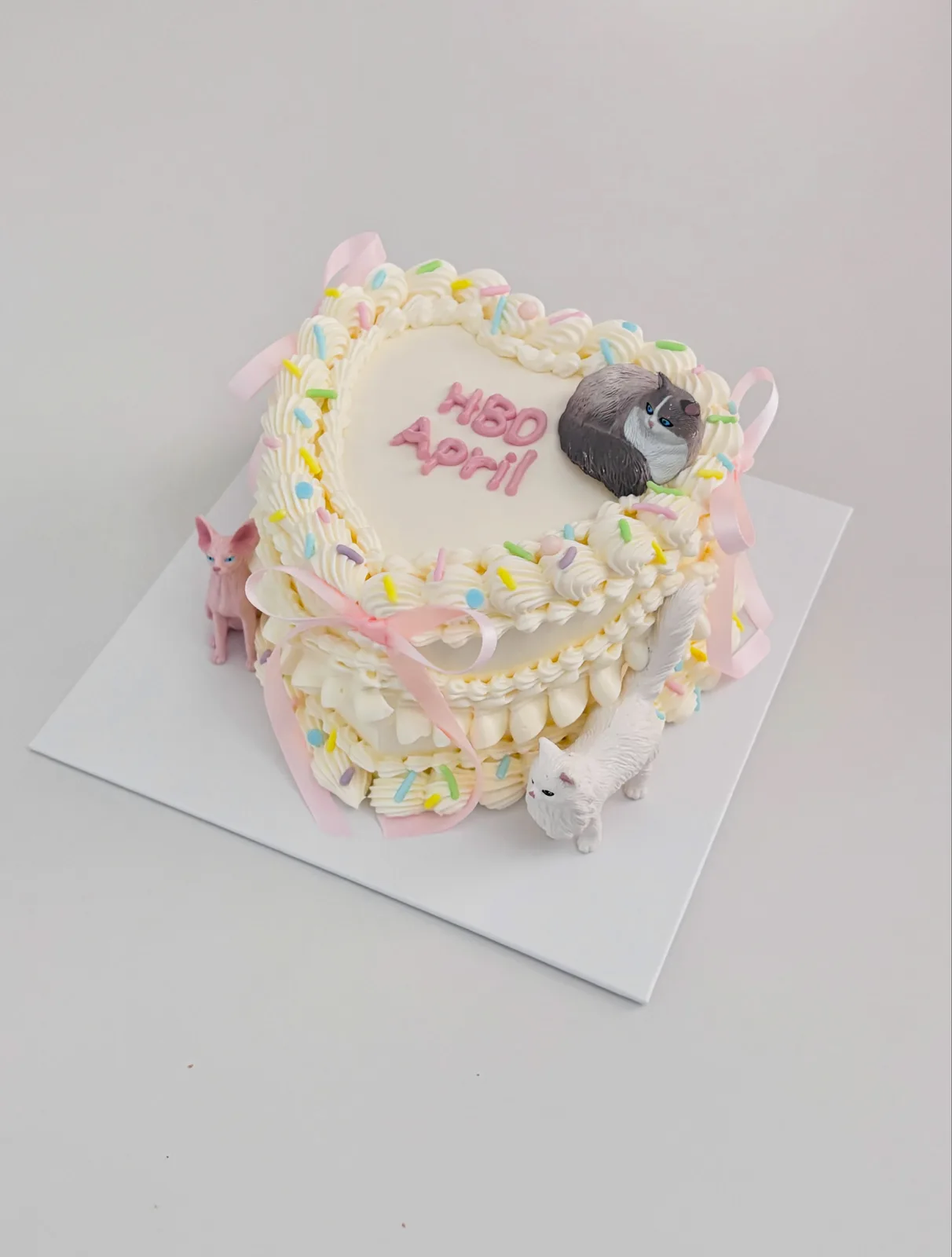 White cake with pastel confetti and animal toppers, custom cake made in Streatham SW16 - Danine Cakes