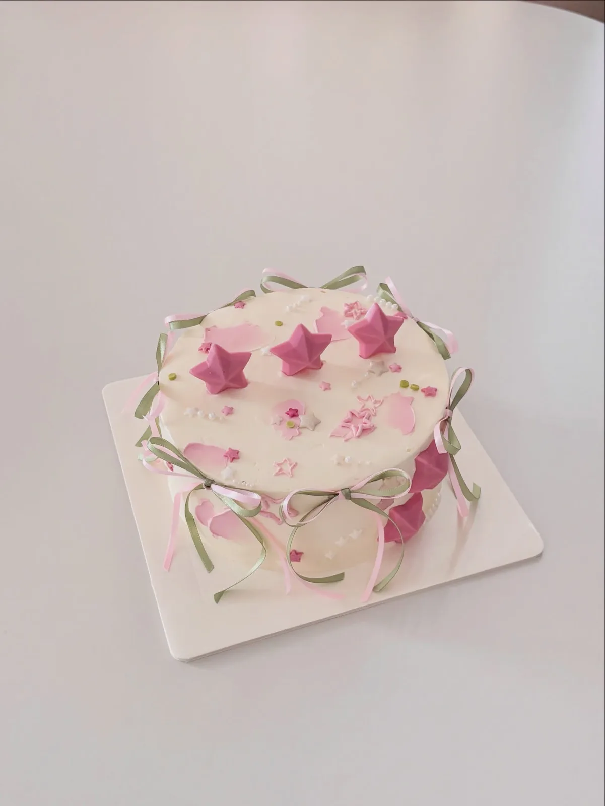 White cake with pink stars and trailing ribbon, custom cake made in Streatham SW16 - Danine Cakes