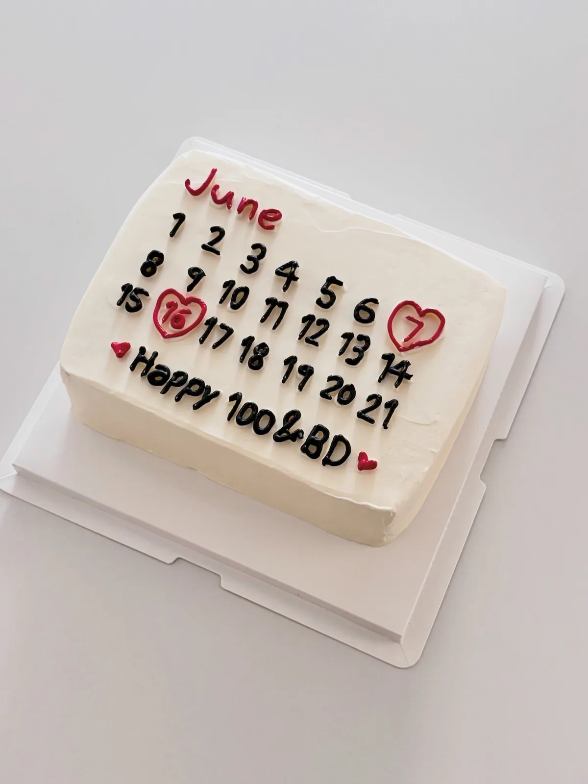 White calendar cake with piped numbers and hearts, handmade to order by Danine Cakes in Streatham, South London