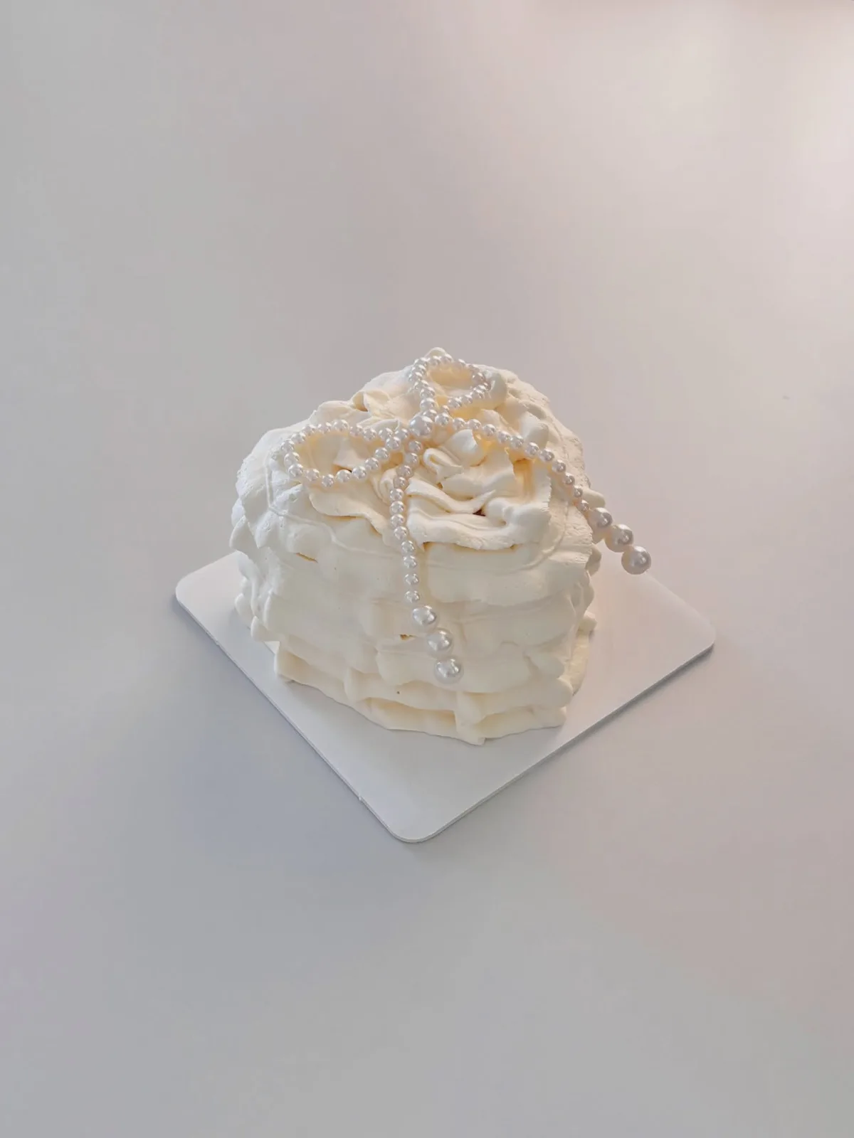 White piped cake with pearls and ruffle border, Korean-inspired custom cake handmade in Streatham, London