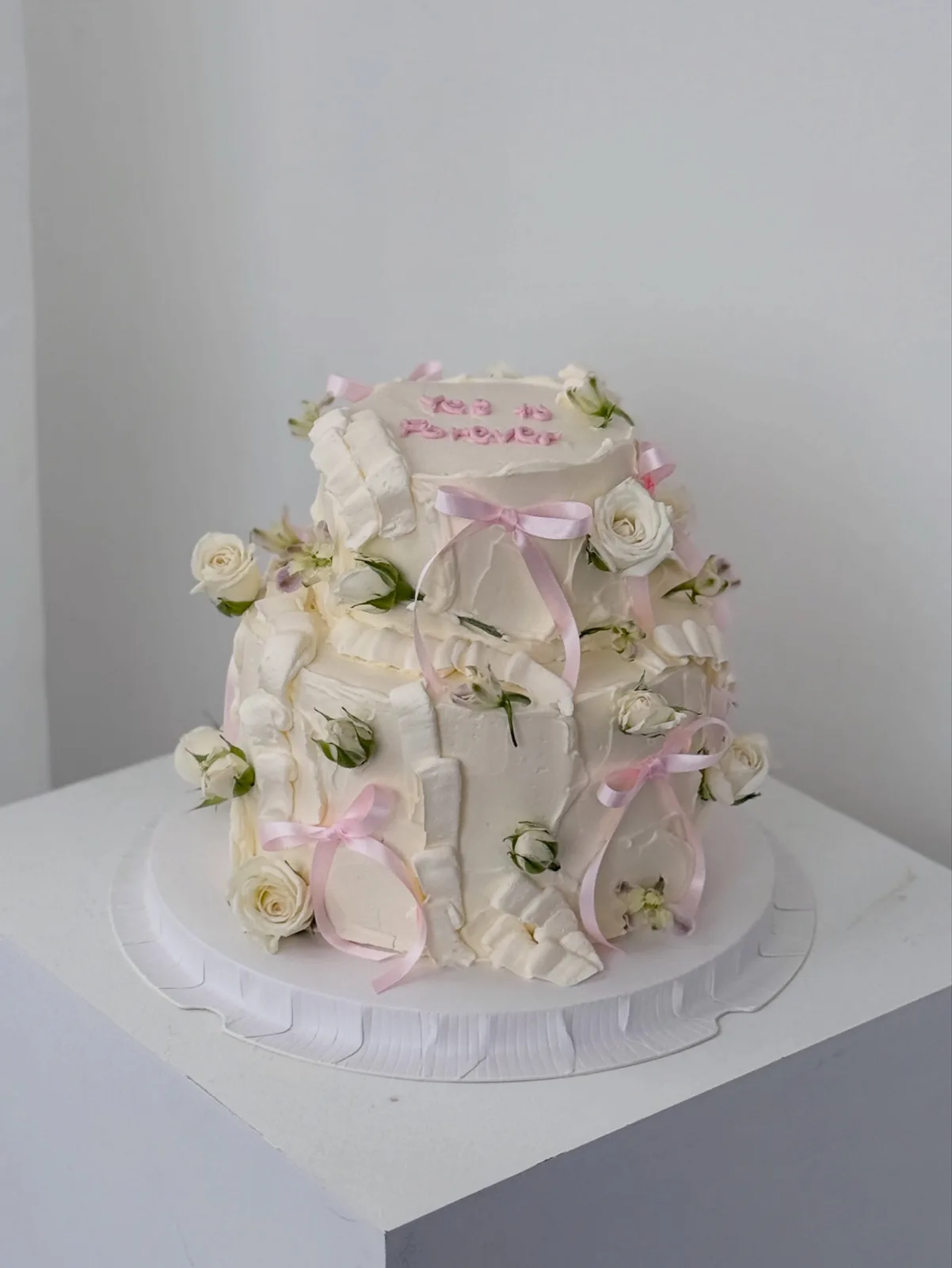 White tiered cake with fresh roses and pink ribbon, handmade to order by Danine Cakes in Streatham, South London
