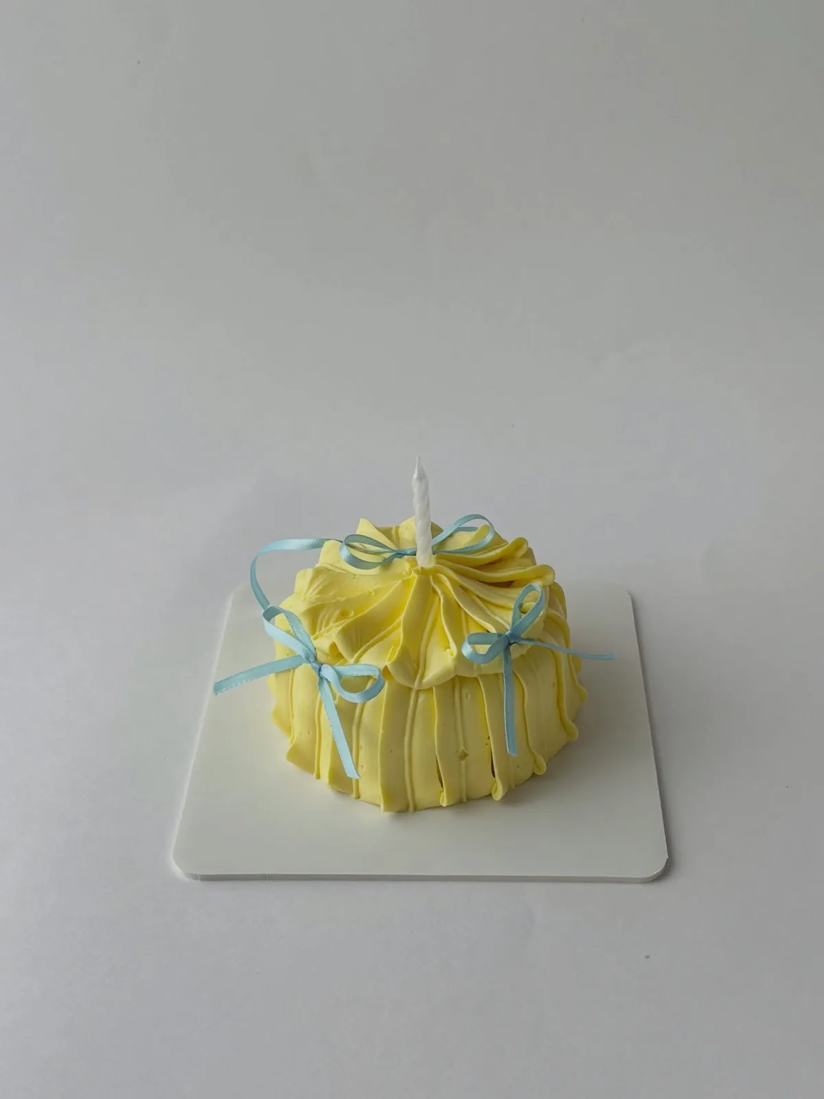 Yellow piped dome cake with blue ribbon bows, custom cake made in Streatham SW16 - Danine Cakes